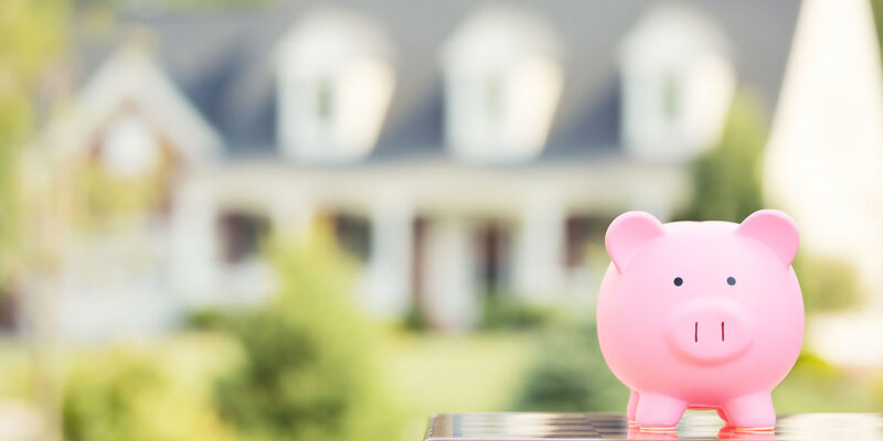 Piggy bank in front of house representing home equity