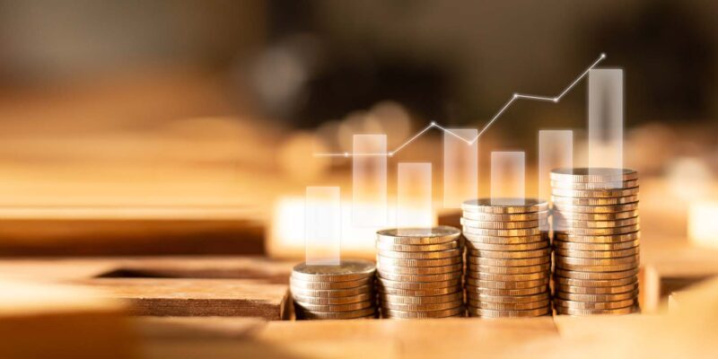 stacks of coins with a trending upward bar graph