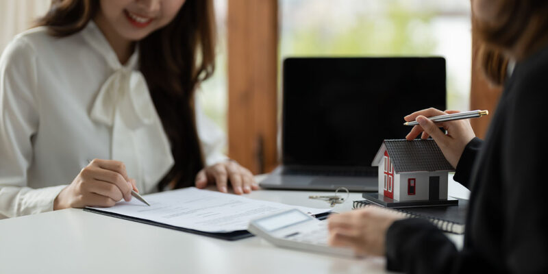 single woman signing with loan officer