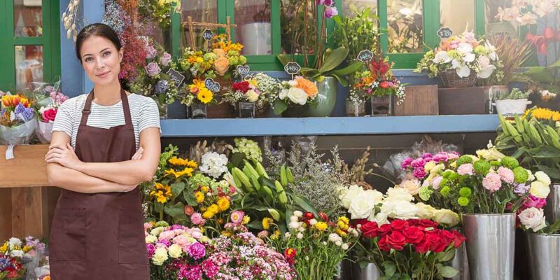 Self employed lady in front of her flower shop