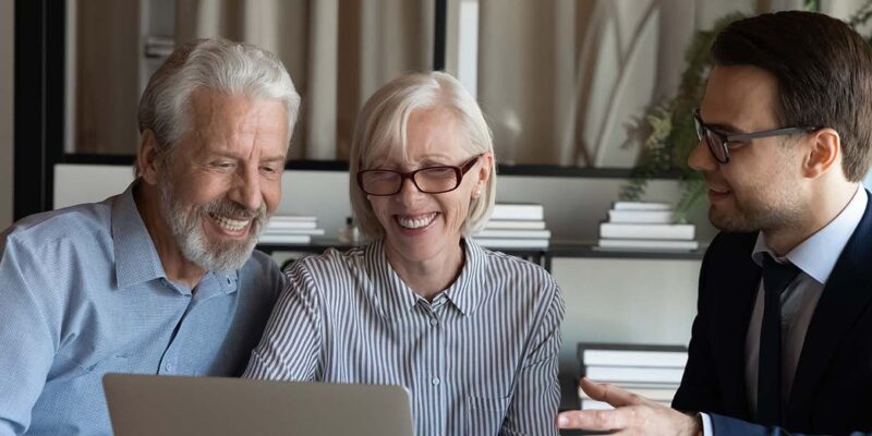 Older couple smiling with loan officer