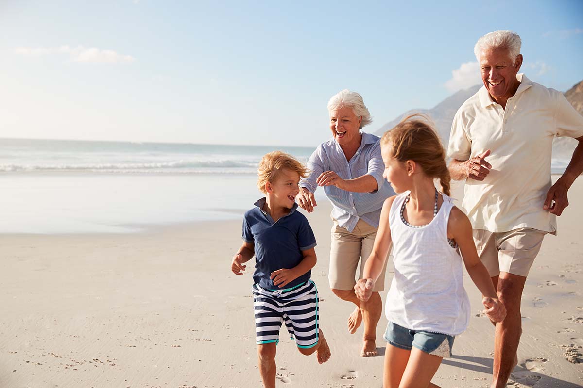 grandparents running on the beach