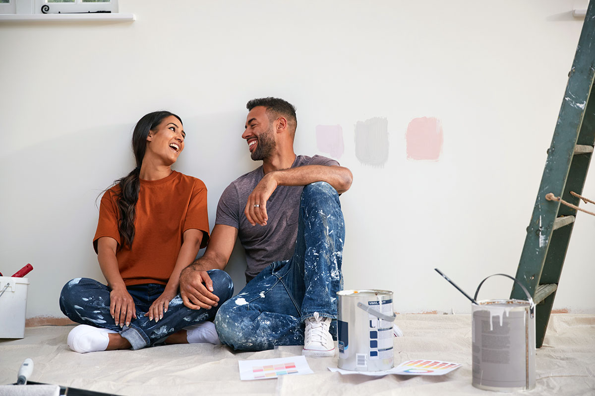 Young couple painting their living room