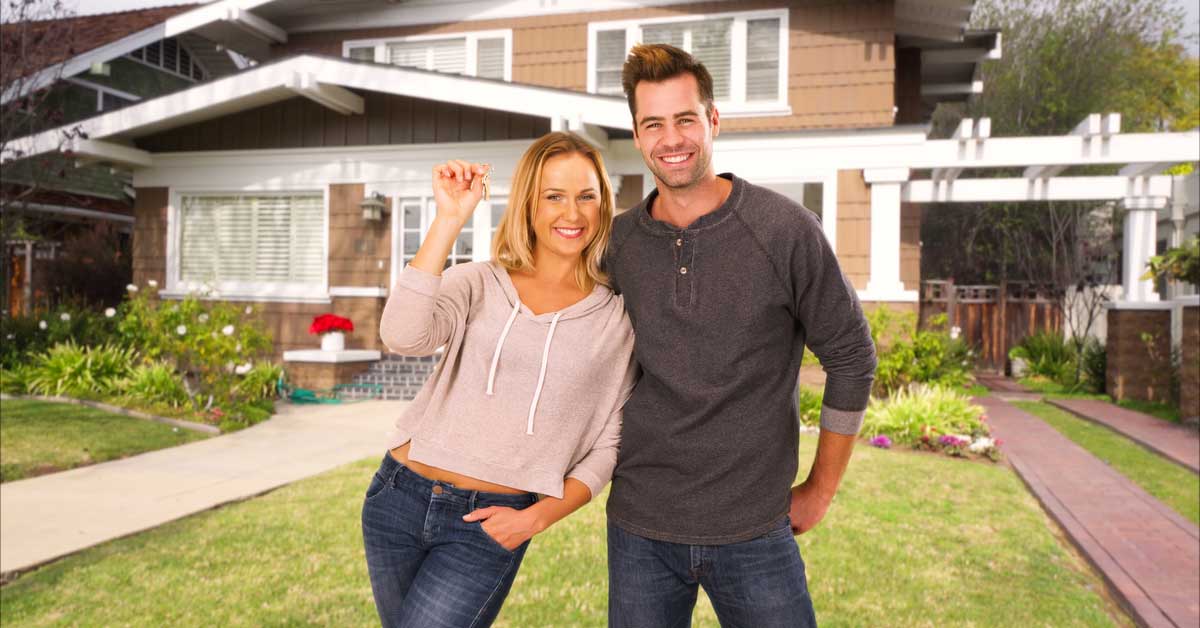 Young couple in front of new home