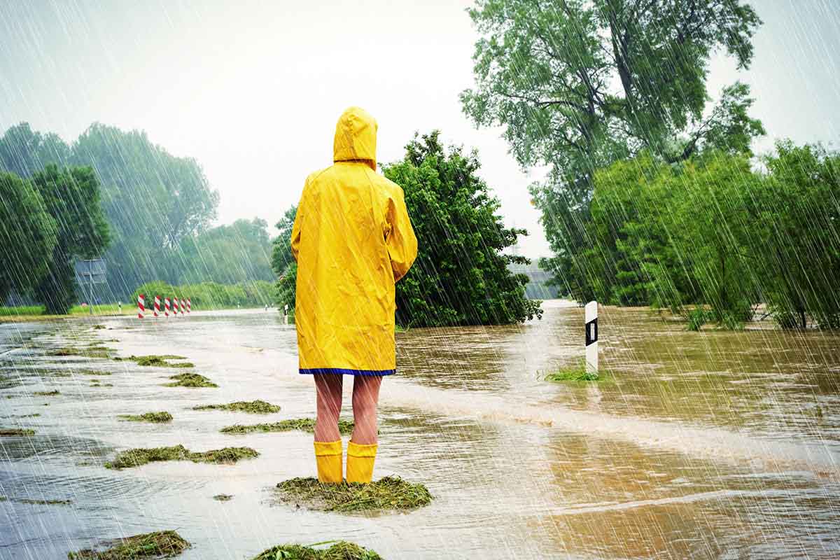 Young woman standing on a flooded street in the rain