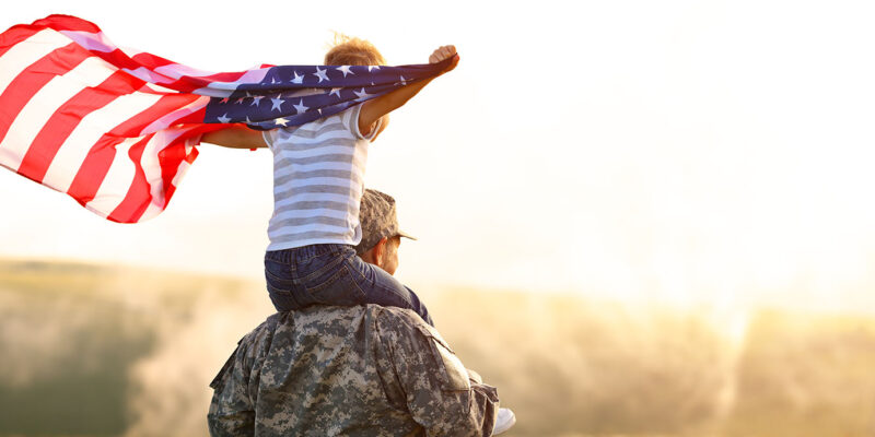 Army Father with Son on Shoulders Holding Flag