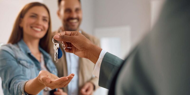 Happy homeowners receiving key to house