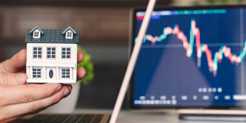 Toy house in front of line graph of 2026 housing market